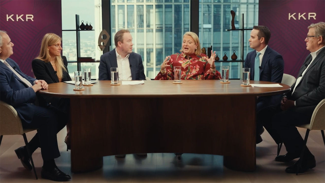 A panel of speakers sitting around a large table. 