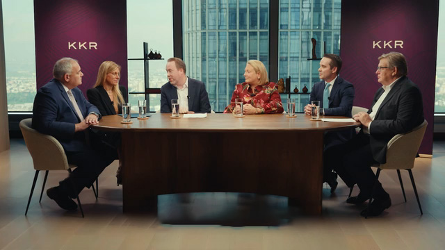 A panel of speakers sitting around a large table. 