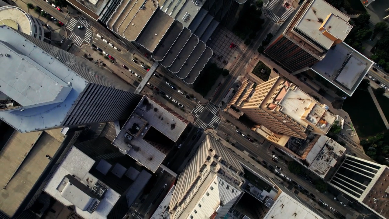 An aerial shot of a city look down through the buildings to the streets. 